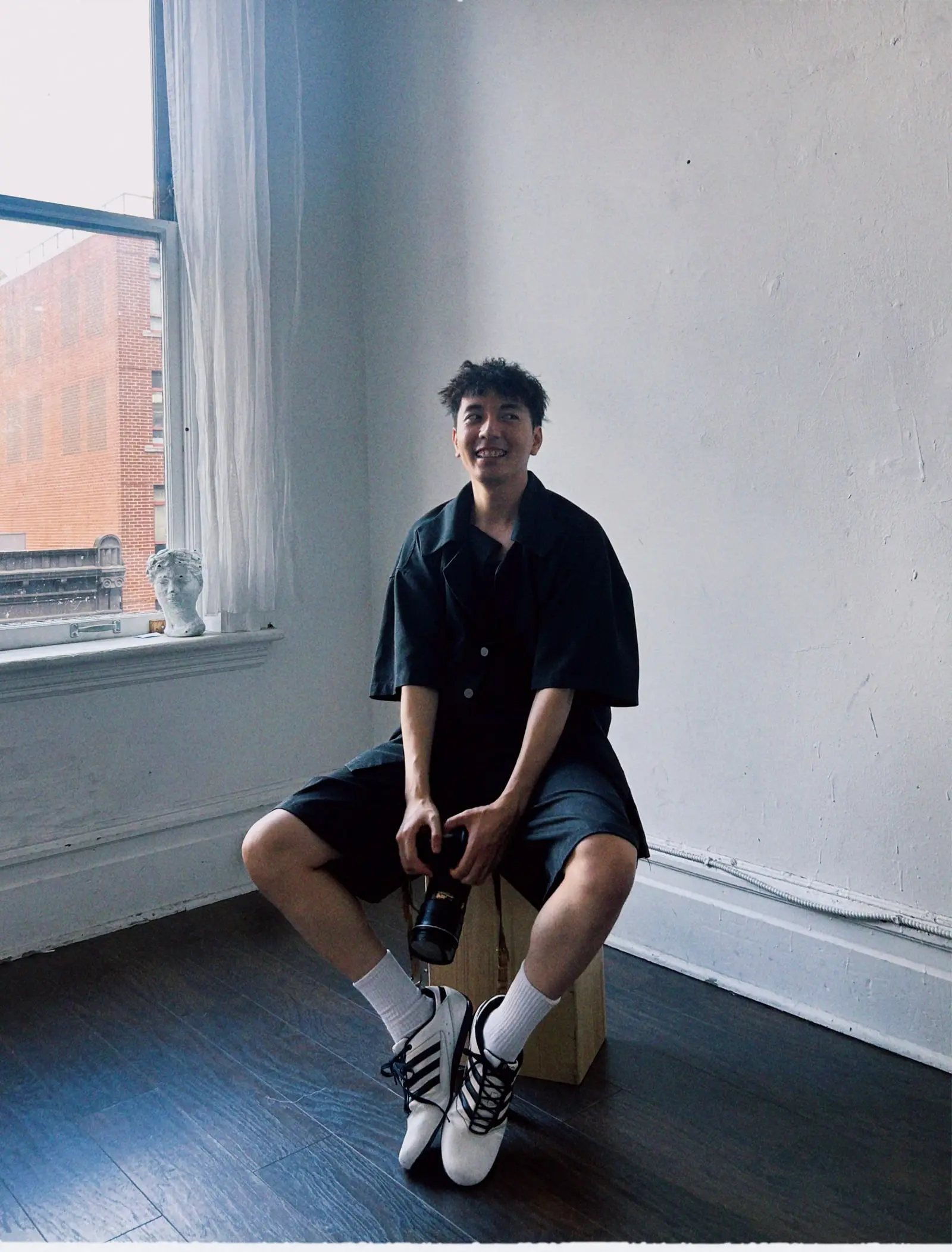 Lucas Trong in his studio, holding his camera